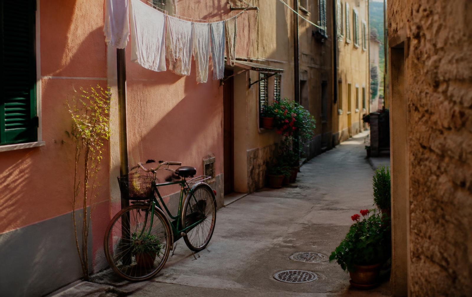 Quiet lane in an Italian town with a bicycle, laundry and geraniums